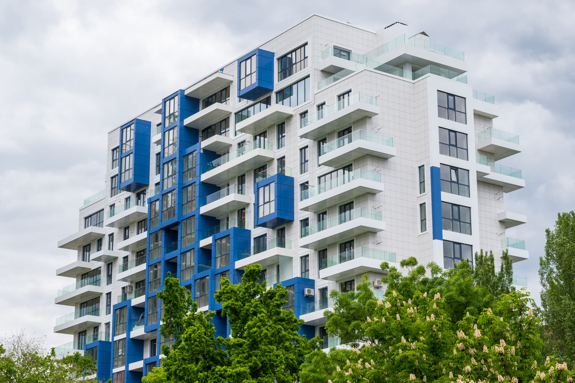 Modern multi-storey residential building with glass balconies