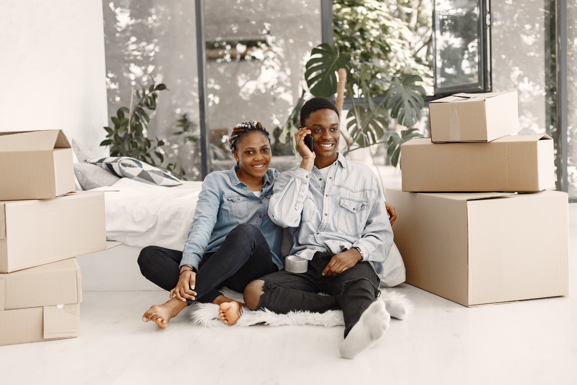 Couple sitting among moving boxes in their new home